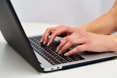 Typing on a laptop at table