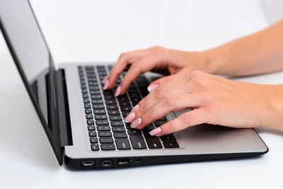 Hands typing on laptop keyboard
