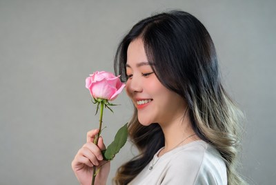 Woman smiles with pink rose