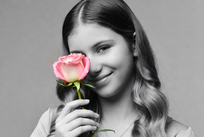 Girl holds rose close to face