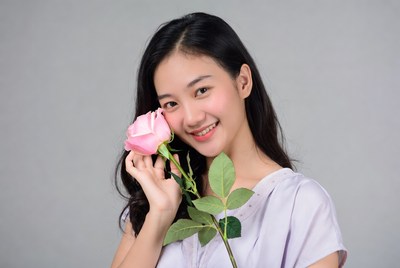 Young woman holding pink rose