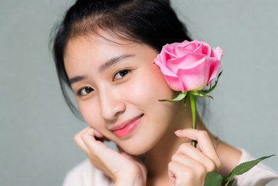 Young woman holding a pink rose