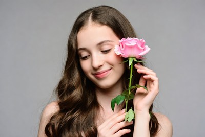 Girl holding pink rose with smile