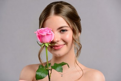Young woman holds pink rose