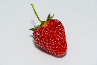 Fresh red strawberry on white surface