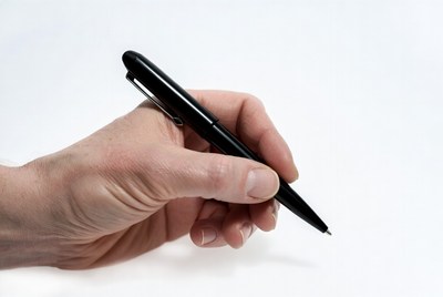 Hand holding a pen in plain view