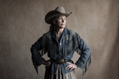 Woman in cowboy attire poses for portrait