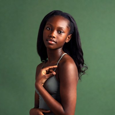 Young woman poses against green backdrop