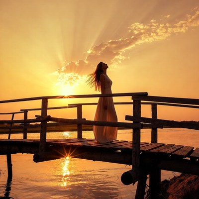 Woman on bridge at sunset