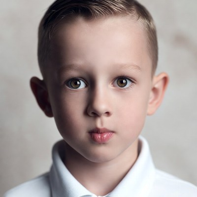 Young boy with serious expression indoors