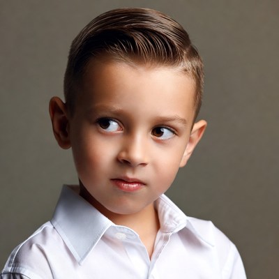 Child with neat hairstyle looking off