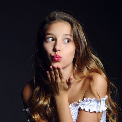 Young girl blowing a kiss with joyful expression