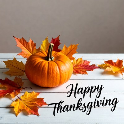 Orange pumpkin with autumn leaves on table