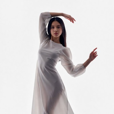 Woman in white dress poses in studio
