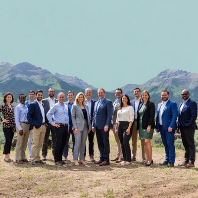 Group in suits outdoors near mountains