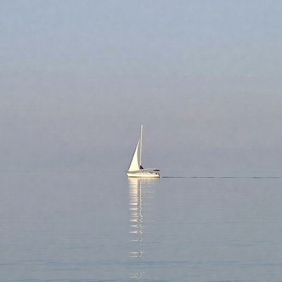 Sailboat on calm water at dawn