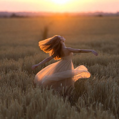Woman dancing at sunset in a field