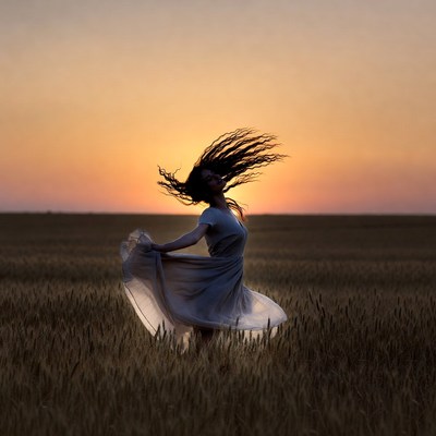 Woman dancing in sunset field