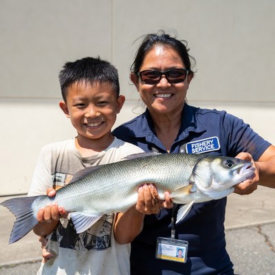 Child and adult hold large fish together