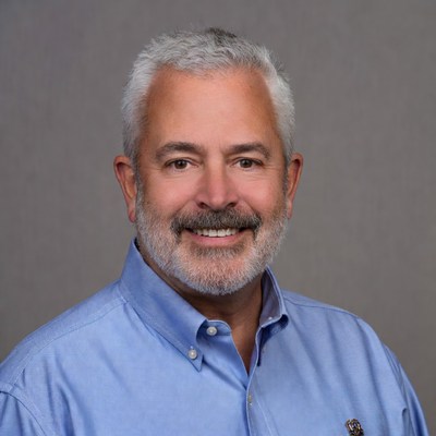 Professional man with silver hair smiles