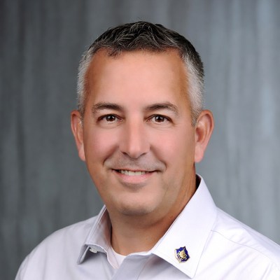 Man in light gray shirt smiles