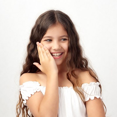 Girl smiling and laughing with hand on face