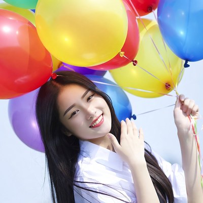 Young woman holds colorful balloons