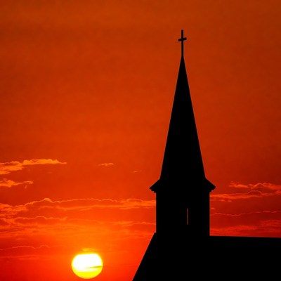 Sunset over church steeple silhouette
