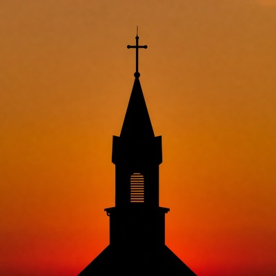 Church steeple against sunset sky