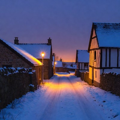 Snowy village street at dusk