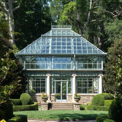 Glass greenhouse in garden setting