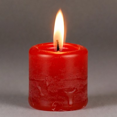 Candle flame burns in dark space