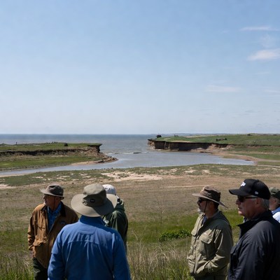 Group observing coastline erosion in spring
