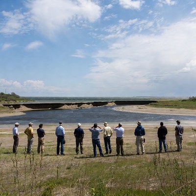 People gather at the riverbank for discussion