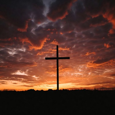 Cross silhouette against sunset sky