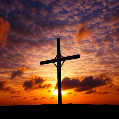 Cross silhouette at sunset in sky