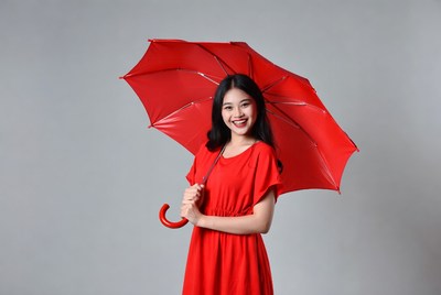 Young woman holding red umbrella indoors