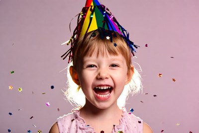 Girl celebrating with party hat and confetti
