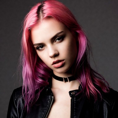Young person with pink hair and dark jacket
