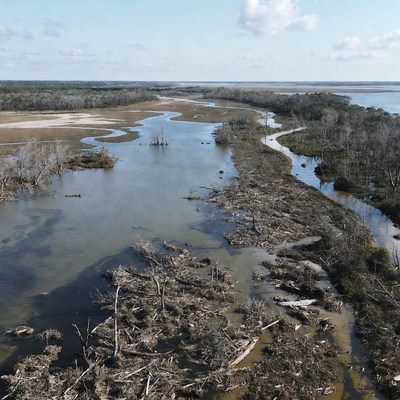 River and land meet under blue sky