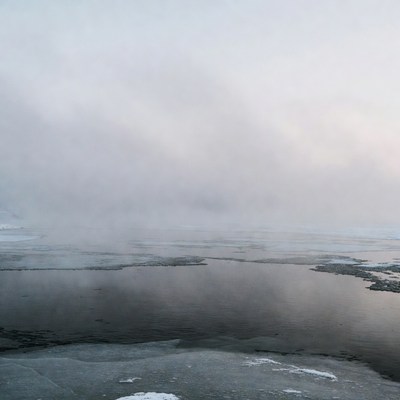 Fog over frozen lake in winter