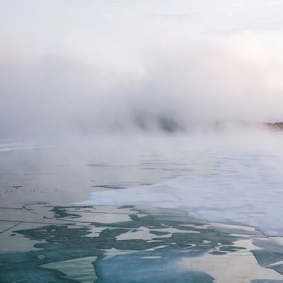 Mist over frozen lake at dawn