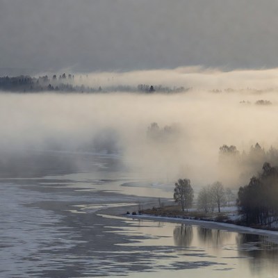 Fog over frozen river in winter