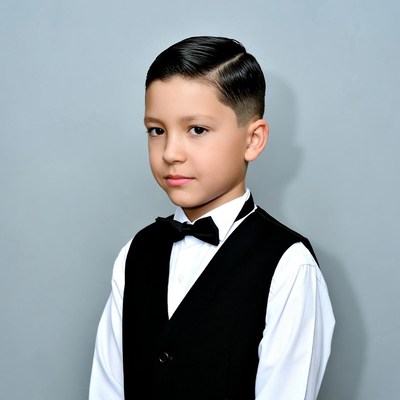 Young boy in tuxedo standing still