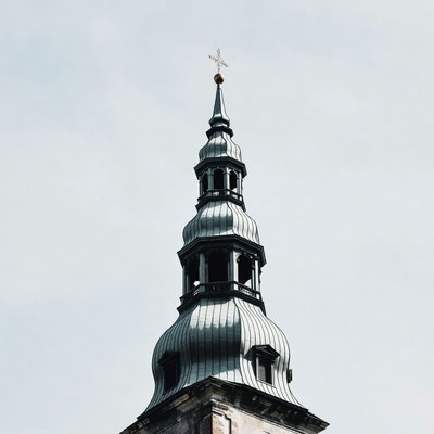 Tall church tower under cloudy sky