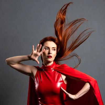 Woman in red cape posing with flowing hair