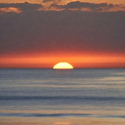 Sunset over the calm ocean horizon