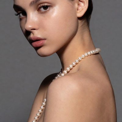 Young woman with pearl necklace in studio