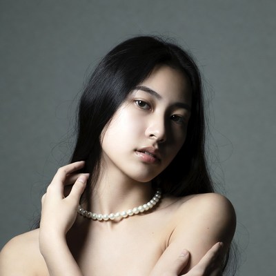 Model poses with pearl necklace in studio