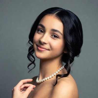 Young girl with pearl necklace smiling